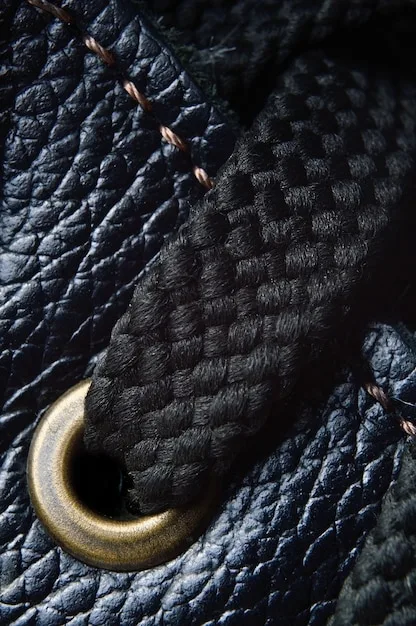 A detailed close-up of custom-made, hand-tooled leather accessories in a dark, intricate style, displayed at a craft fair booth, emphasizing artisanal quality and unique subculture fashion.