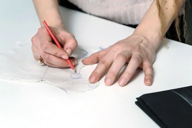 A close-up of an artist's hand sketching a detailed underground fashion design using a fine-liner pen, with a mix of traditional and digital tools visible in the background, suggesting a versatile approach.