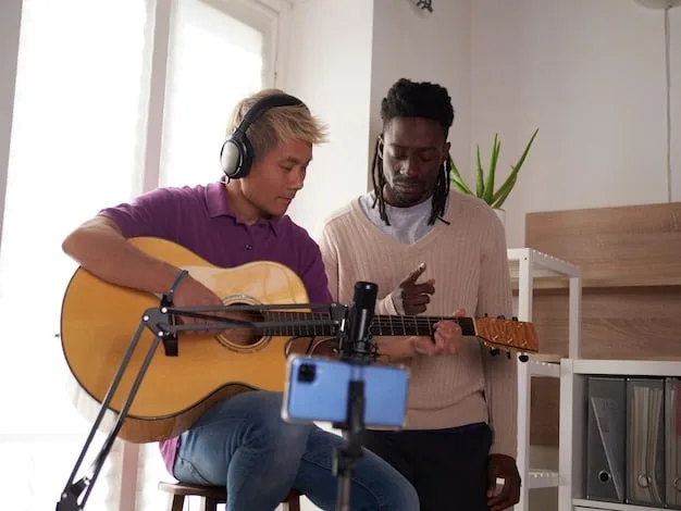 Two musicians recording a TikTok video together in a home studio. One is playing a guitar while the other is singing into a microphone. They are laughing and interacting, with smartphones and recording equipment visible in the background. The scene captures the dynamic and fun atmosphere of musical collaboration on TikTok.