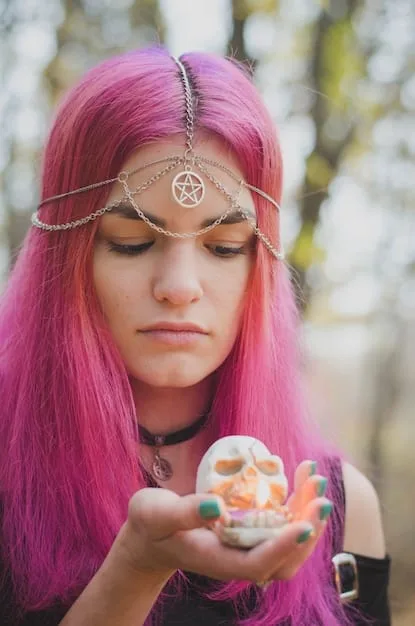 A young woman with colorful hair and tattoos wearing a pentacle necklace. She is standing in a garden filled with lush greenery and flowers, holding a book of shadows in her hands. Her expression is serene and confident, embodying a modern pagan aesthetic.