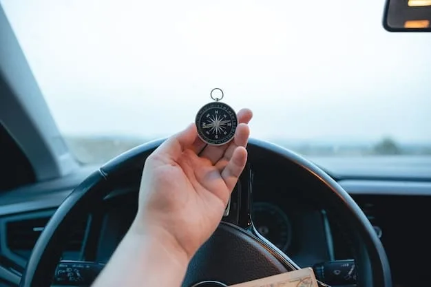 A close-up photo of a hand holding a map, with a compass and a set of keys on top. The background is blurred, showing a van's dashboard and steering wheel.