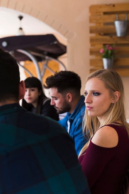 A photograph of an immersive theater performance where audience members are interacting with actors in a dimly lit, atmospheric space, highlighting the blurring of boundaries and the sense of being part of the story.