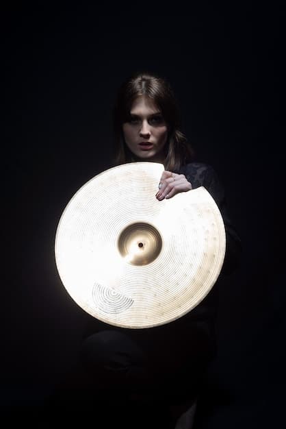 A close-up of a DJ wearing dark clothing and occult symbols, playing vinyl records in a dimly lit space. The DJ's face is partially obscured by shadows, enhancing the mysterious atmosphere.