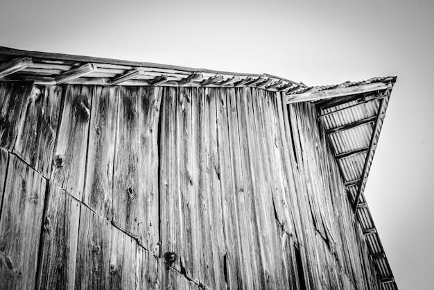 An evocative black and white wet plate collodion photograph of a weathered barn, showcasing incredible detail and a timeless quality.
