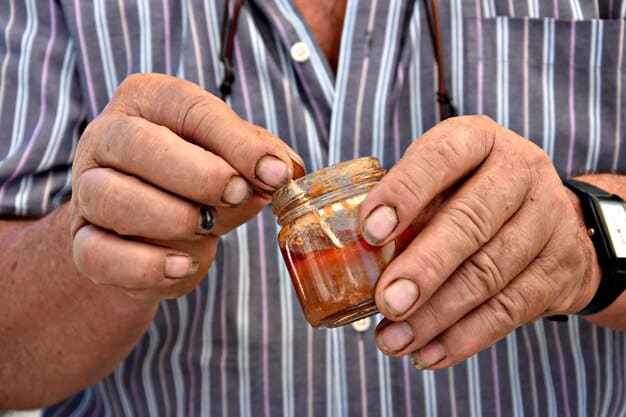 A close-up shot of Chef Juniper carefully examining a bubbling jar of kombucha in their dimly lit, industrial-chic kitchen. The focus is on the details of the fermentation process and the chef's intense concentration.
