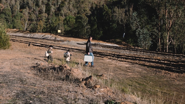 A dramatic photograph displaying a group of environmental activists blockading a logging road in a dense forest, with some members chaining themselves to heavy machinery. The scene conveys a sense of urgency and determination, highlighting the lengths to which these activists are willing to go to protect endangered ecosystems. The contrast between the natural environment and the industrial equipment emphasizes the conflict at the heart of the dark ecology movement.