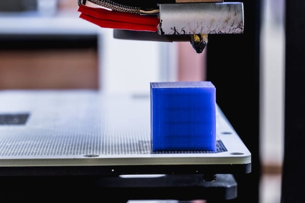 A close-up of a 3D printer creating a complex plastic object layer by layer. The printer is in operation, and the object is partially complete.
