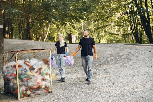 A group of individuals dressed in punk-inspired attire are shown cleaning up a polluted urban waterway. They are collecting trash, planting native vegetation, and painting environmental murals on nearby walls, showcasing the fusion of punk aesthetics with direct environmental action.