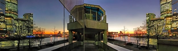 A split-screen image contrasting a luxurious, high-tech penthouse apartment with a crowded, impoverished urban slum, both in a major US city. The visual juxtaposition highlights the stark socioeconomic disparities within American society.