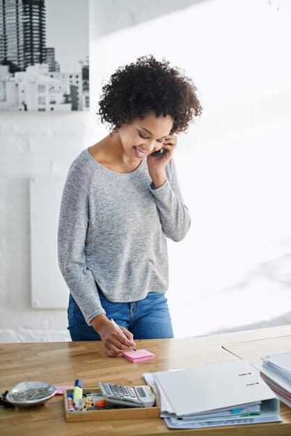 An artist smiling confidently while organizing their tax documents in a well-organized binder, representing preparedness and control over their finances.