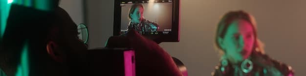 A behind-the-scenes shot of a small, energetic music video set. The image shows a group of friends working together, some holding lights, others adjusting the camera, and the artist performing. The setting is a cozy, creatively decorated room.