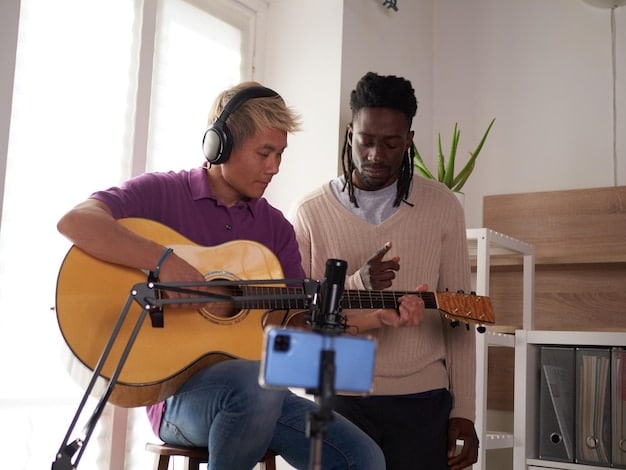 Two musicians recording a TikTok video together in a home studio. One is playing a guitar while the other is singing into a microphone. They are laughing and interacting, with smartphones and recording equipment visible in the background. The scene captures the dynamic and fun atmosphere of musical collaboration on TikTok.