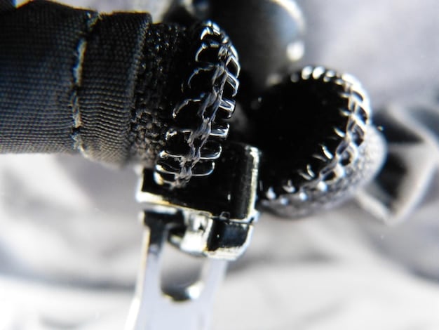 Close-up of unique details on a vintage punk rock jacket, showcasing safety pins, patches, and hand-painted designs. The jacket is worn but well-maintained, illustrating the character of vintage underground fashion.