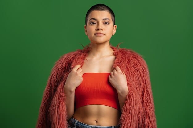 A close-up shot of a model wearing a neon green crop top paired with high-waisted black pants. The model has bold, graphic eyeliner in a matching neon green, and their hair is styled in a futuristic, edgy cut. The background is a dark, gritty urban setting, emphasizing the underground fashion vibe.
