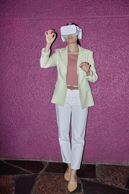 A digital fashion influencer wearing a virtual reality headset, showcasing a digitally rendered outfit with glowing neon accents and intricate geometric patterns. The background is a surreal, futuristic cityscape.