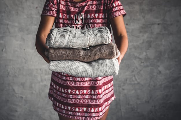 Close-up shot of hands sorting through a pile of old clothes at a thrift store, focusing on textures and patterns that could be repurposed into a new garment. A variety of fabrics are visible, including denim, cotton, and leather.