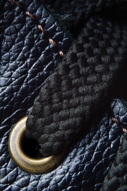 A detailed close-up of custom-made, hand-tooled leather accessories in a dark, intricate style, displayed at a craft fair booth, emphasizing artisanal quality and unique subculture fashion.