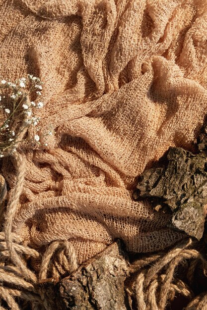 A close-up of a garment made from sustainable, textured fabric in a muted earth tone, juxtaposed with subtle iridescent details from a digitally inspired color palette, worn by a person with alternative styling.